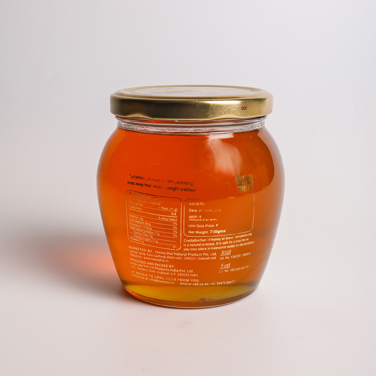 a close up of a orange jar on a white surface 